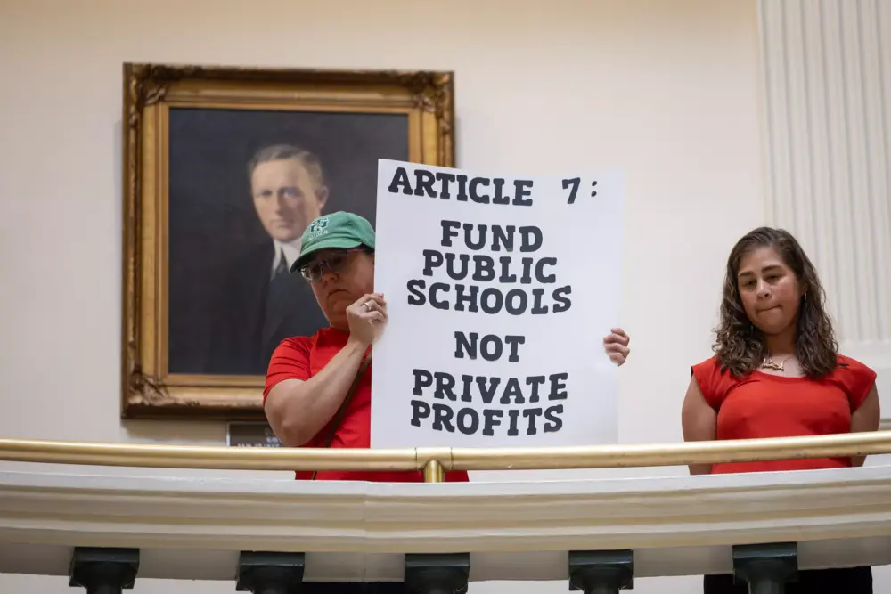 Protestors chant and hold signs in the main rotunda of the Texas State Capitol Building ahead of the Texas House vote on a school voucher program on Wednesday, April 16, 2025, in Austin.