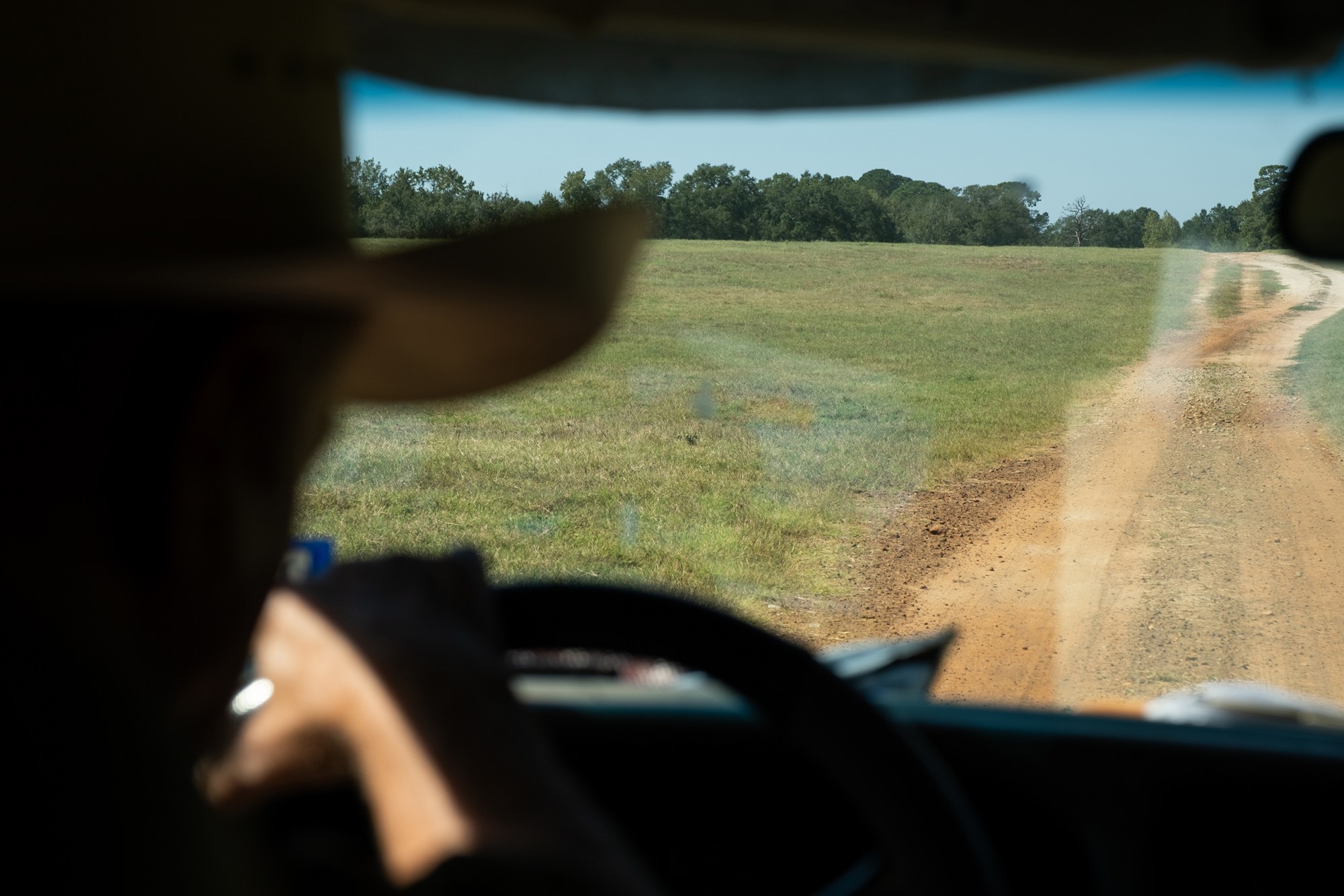Bob Sanders steers his pickup along a dirt road on his East Texas ranch.
