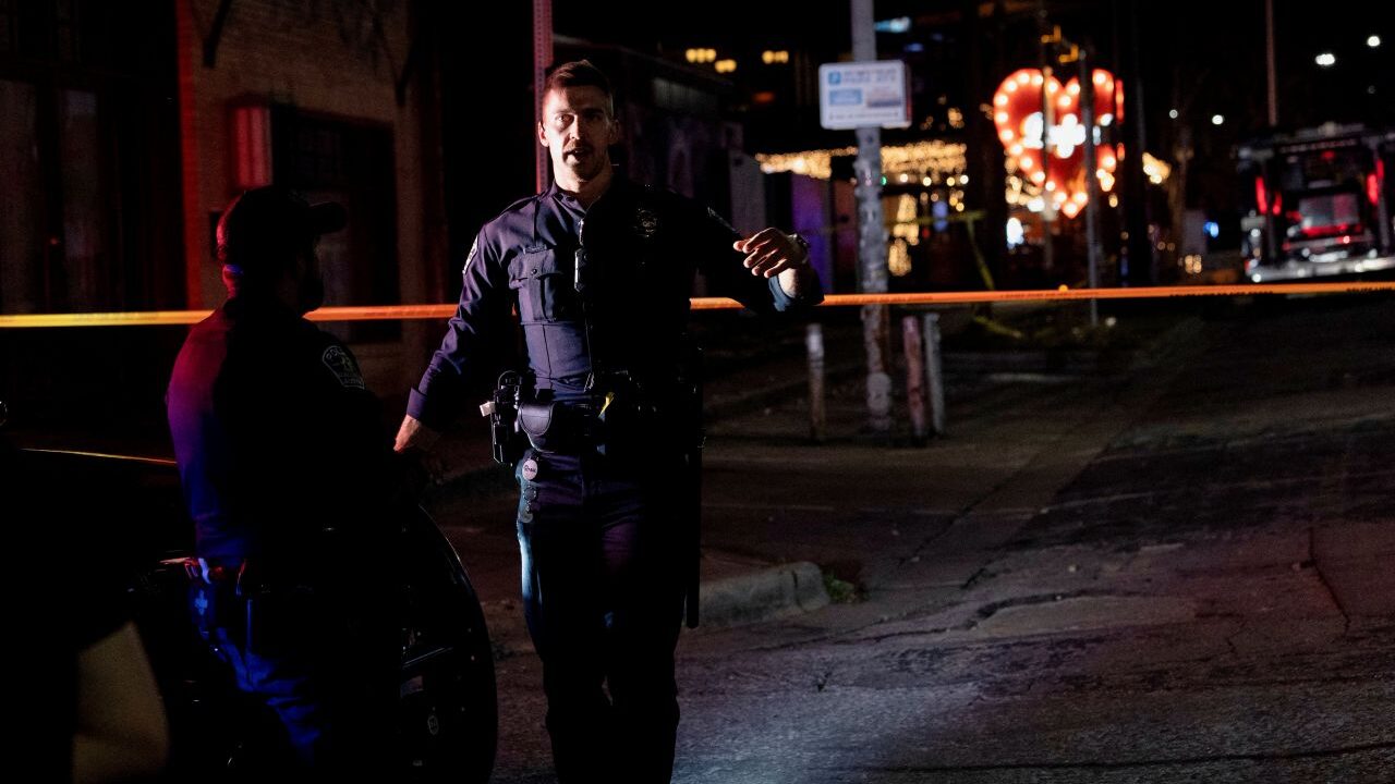 Night image of an Austin, Texas, police officer at a homicide scene outside a bar
