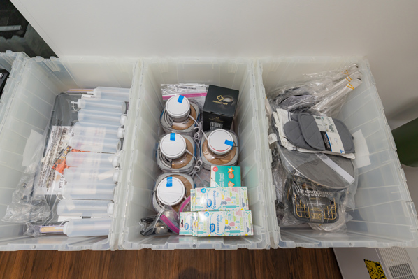 An assortment of cooking supplies within one of the kitchen supply cart bins are pictured.