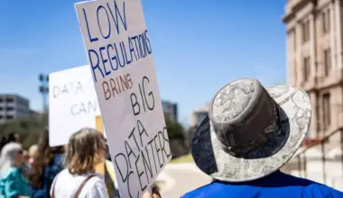 A protestor holds a sign during a rally against the rapid expansion of data centers across Texas on Feb. 23, 2026, at the Texas State Capitol building in Austin.