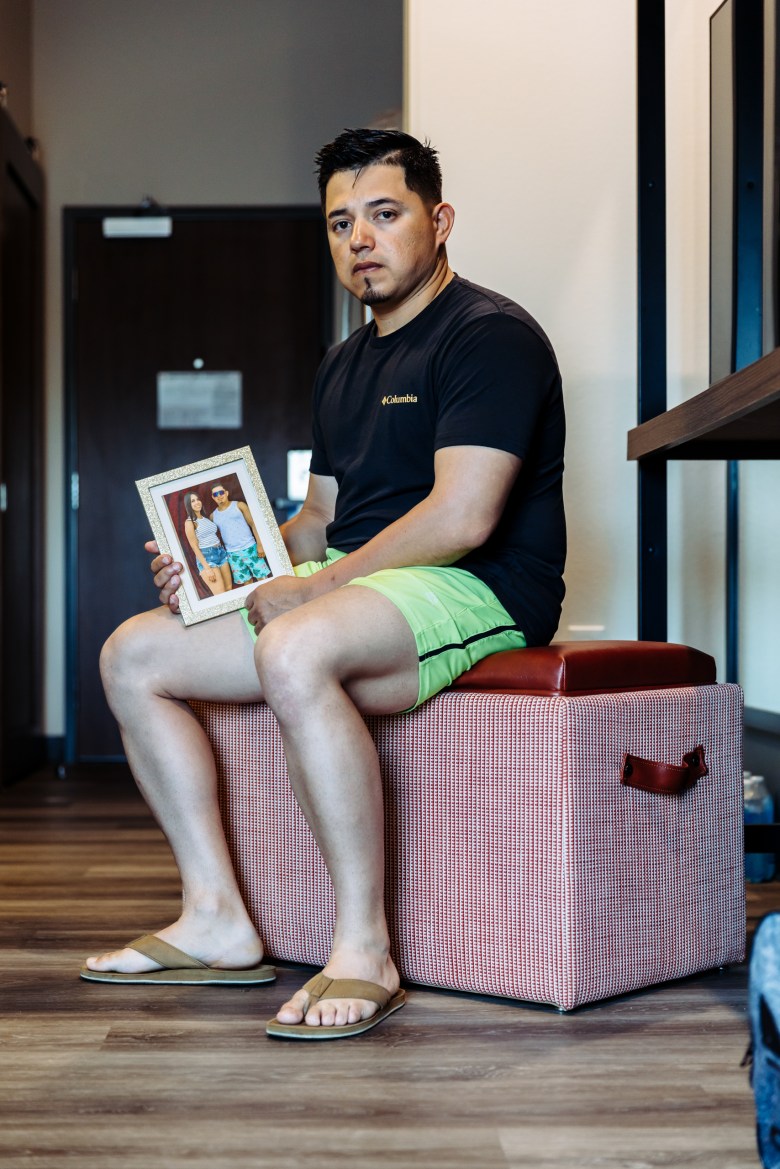Juan Rodriguez sits in his hotel room at Everhome Suites in San Antonio while holding a framed photograph of his fiancée, Johanny Carolina Lacruz Villalobos. Rodriguez said Lacruz Villalobos, a Venezuelan woman who entered the country through the CBP One app, was detained by ICE during their travel to San Antonio and is now being held at a detention facility in Raymondville.