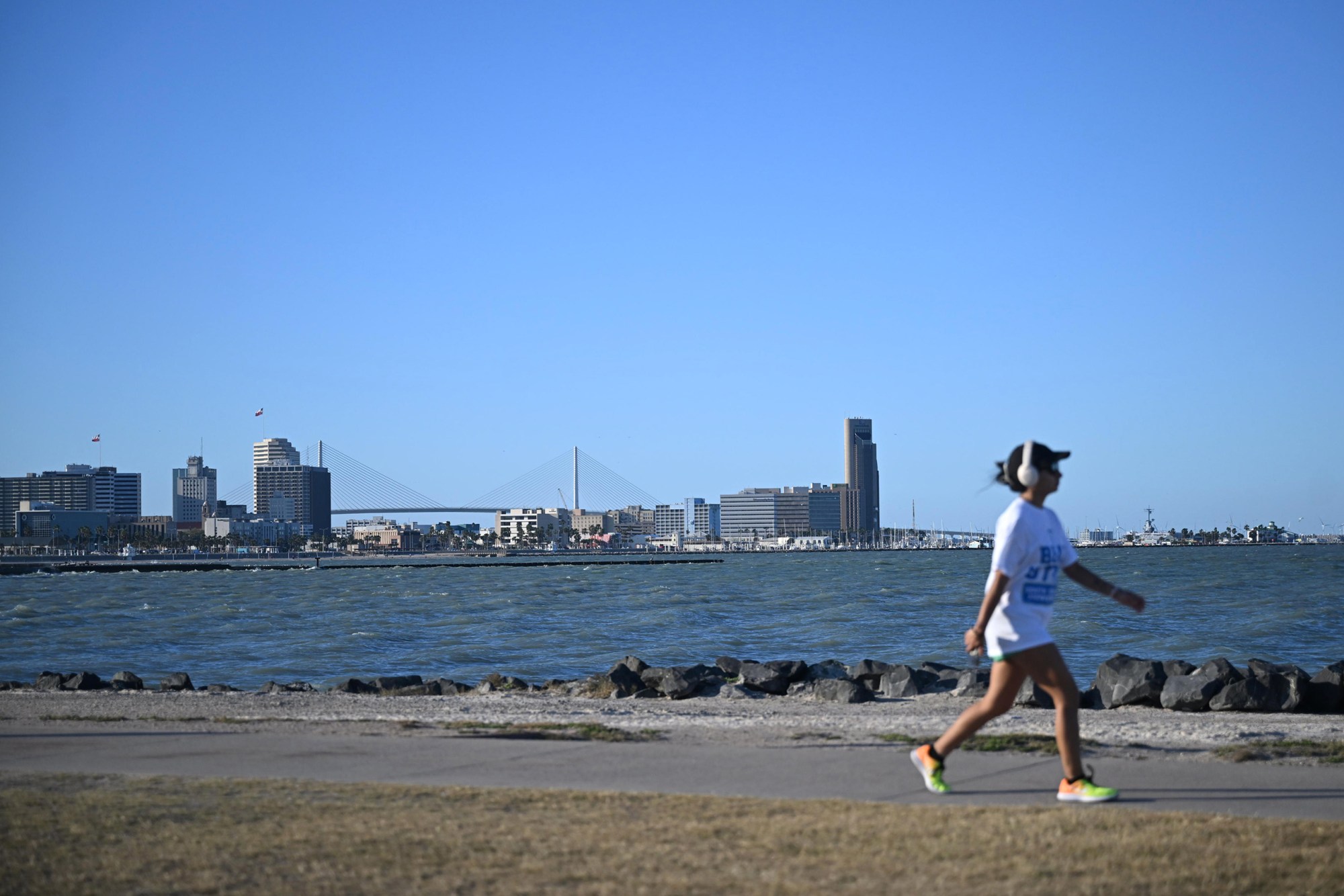 A person out for a walk in Cole Park with downtown Corpus Christi as a backdrop on March 19, 2026.