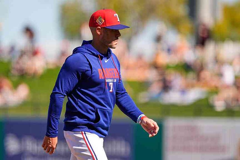 Texas Rangers manager Skip Schumaker walks back to the dugout after making a pitching change during the second inning of a spring training baseball game against the Colorado Rockies, Sunday, Feb. 22, 2026, in Surprise, Ariz. (AP Photo/Charlie Riedel)