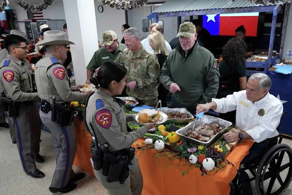 Incoming U.S. Border Czar Tom Homan, second from right, and Texas Gov. Greg Abbott, right, help serve meals to state troopers and national guardsmen taking part in Operation Lone Star at a facility on the U.S.-Mexico border, Tuesday, Nov. 26, 2024, in Eagle Pass, Texas. (AP Photo/Eric Gay) (Eric Gay/AP)