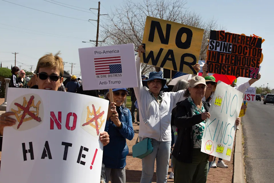 Protesters hold up signs stating "No hate" and "No war" during the third "No Kings" protest against President Donald Trump in El Paso, Texas, on March 28, 2026.