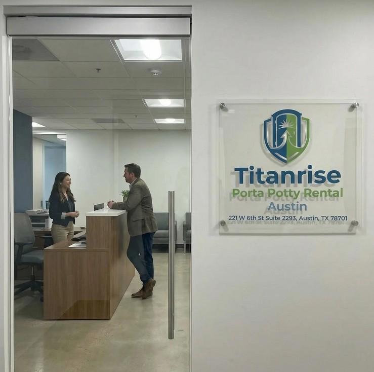 The official office signage of Titanrise Porta Potty Rental Austin, prominently displayed at the entrance of the company