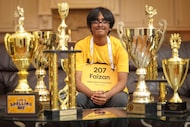 Faizan Zaki, champion of 2025 Scripps National Spelling Bee, poses with some of his trophies...