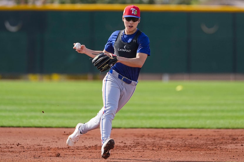 Texas Rangers two-way prospect Seong-Jun Kim participates in a fielding drill during of a...