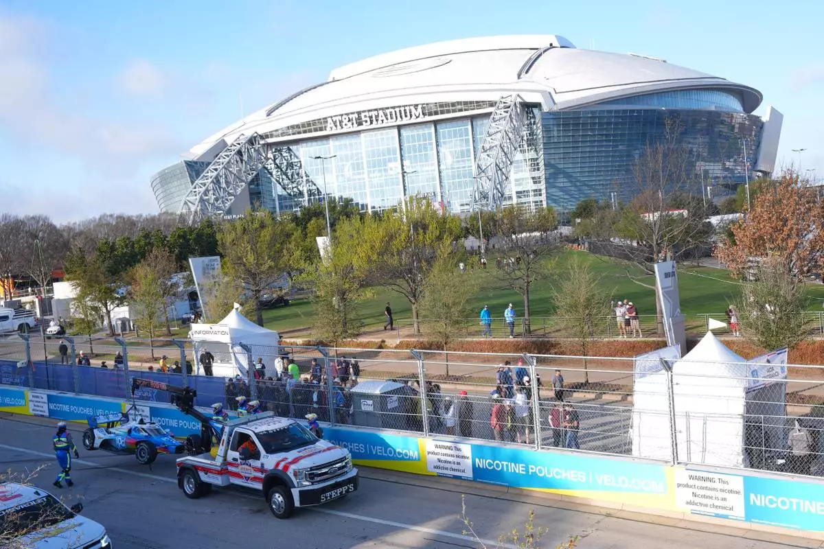 Emergency crew moves driver Josef Newgarden's car after he hit a wall during practice for IndyCar Grand Prix of Arlington auto race, Saturday, March 14, 2026, in Arlington, Texas. (AP Photo/LM Otero)