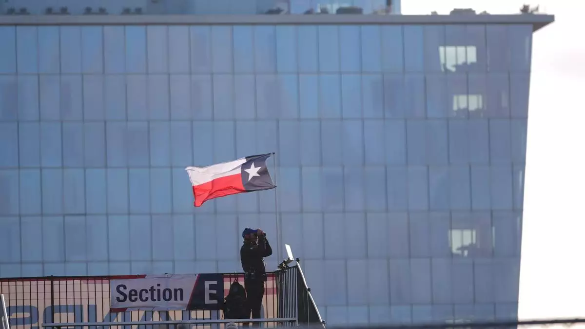 A lone auto race fan watches practice runs for the IndyCar Grand Prix of Arlington auto race, Saturday, March 14, 2026, in Arlington, Texas. (AP Photo/LM Otero)