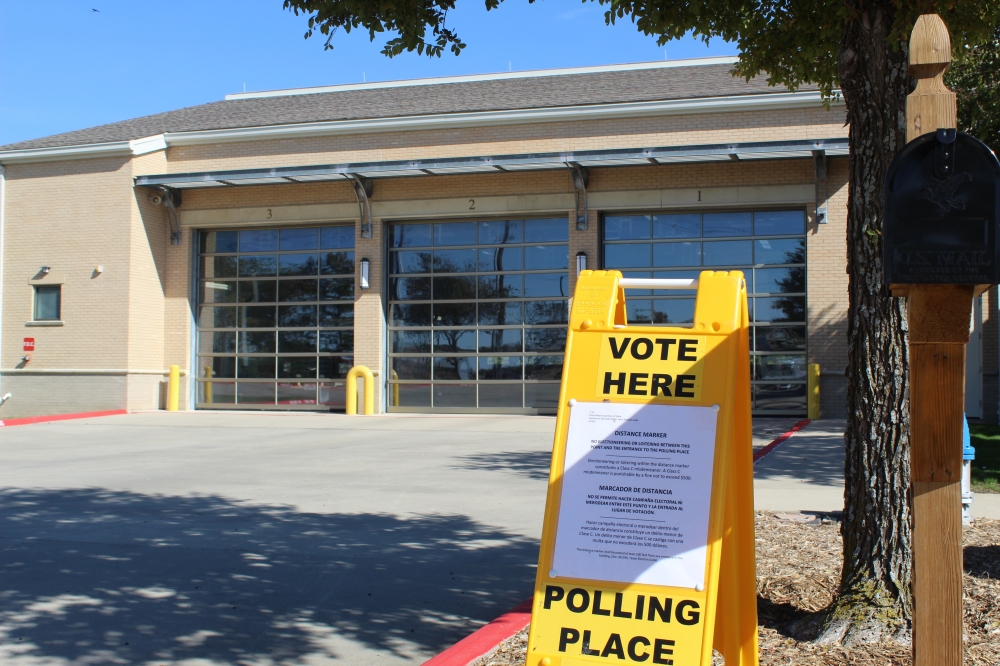 Vote here sign in front of a building
