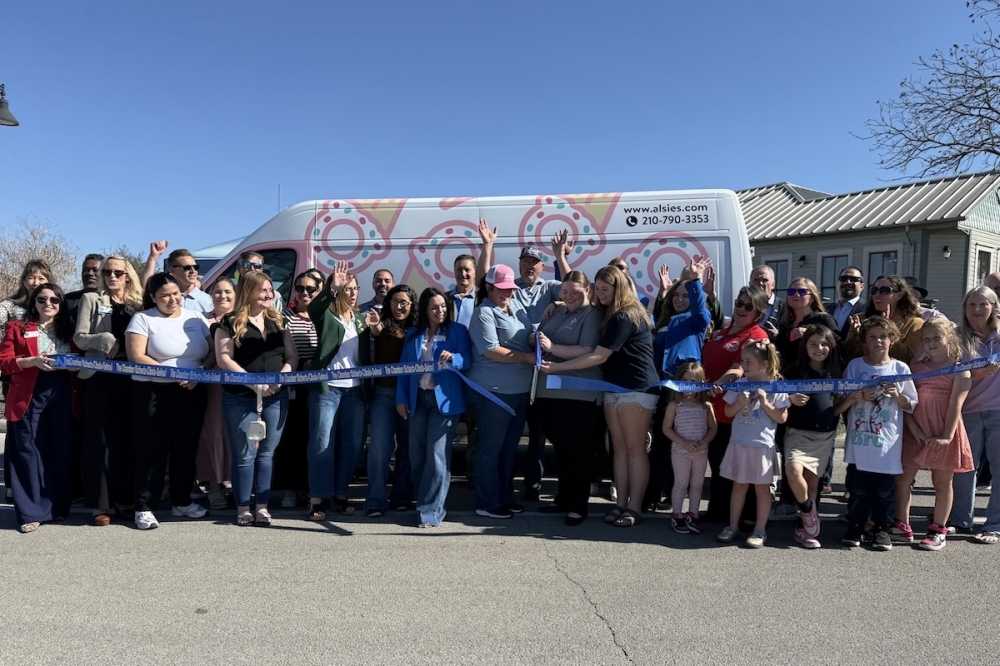 A ribbon being cut in front of an ice cream truck.