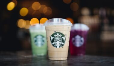 Three clear plastic cups featuring Starbucks logos and filled with three different colored beverages.
