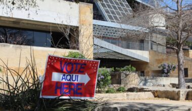 A sign says "vote here" in front of a polling place