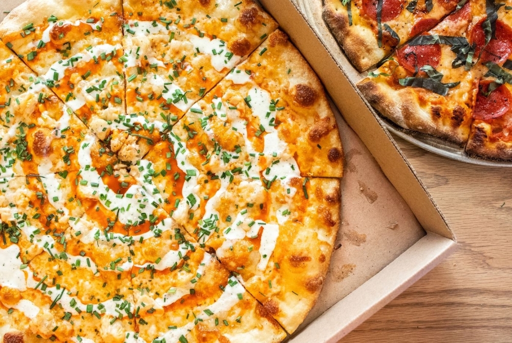 A buffalo chicken pizza in a box from Zalat Pizza.