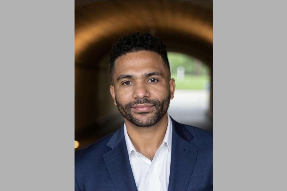 Headshot of man in navy suit and white dress shirt