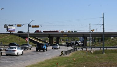 Cars driving on a road under a bridge
