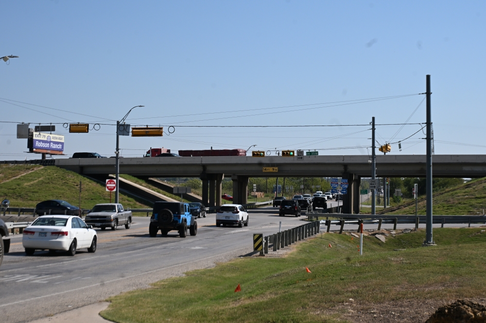 Cars driving on a road under a bridge
