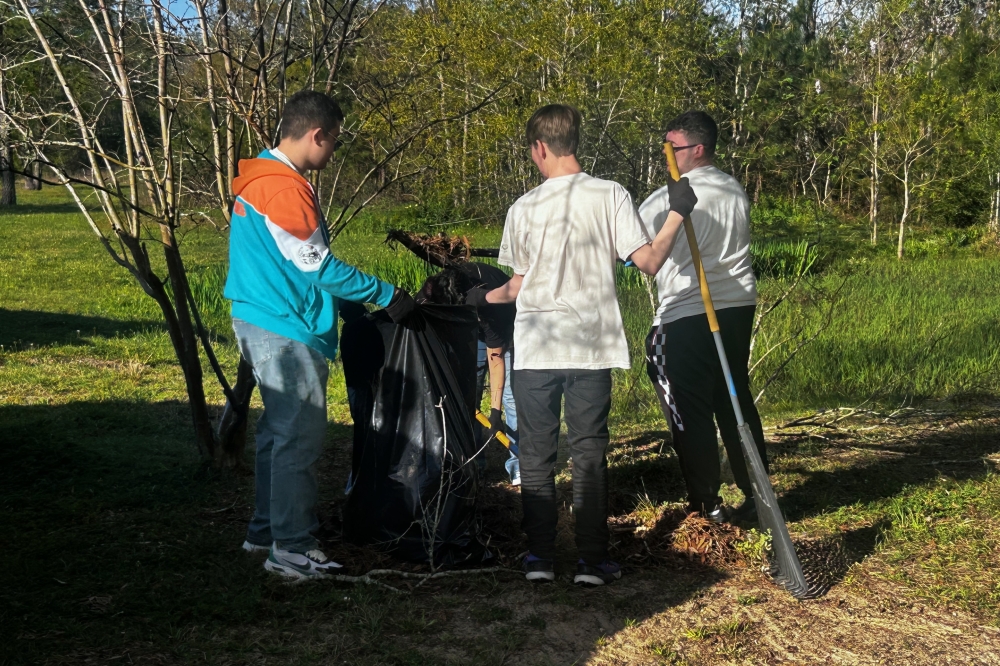 Lake Houston Outreach students picking up trash outside