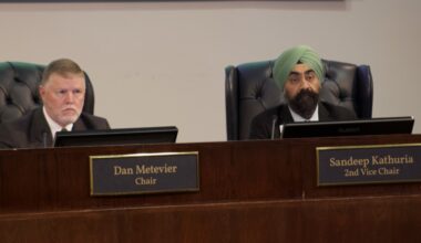 people sitting at a dais in a meeting room