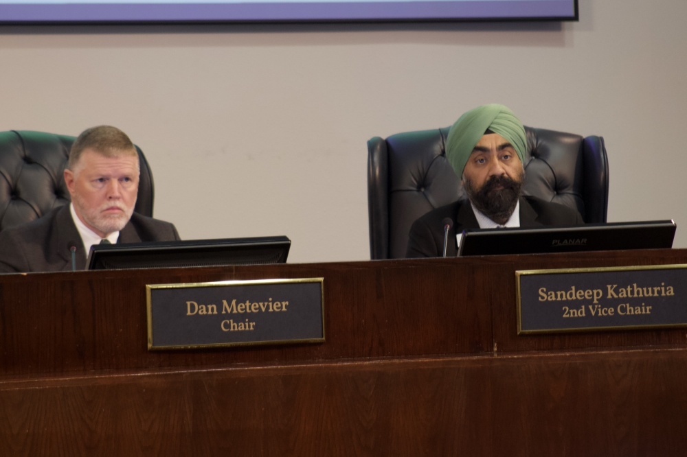 people sitting at a dais in a meeting room