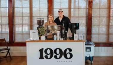 The owners of the coffee service stand behind the counter of the coffee cart.