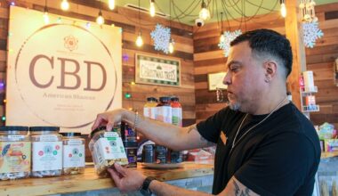 Ryan Martinez holds up hemp-derived THC products at a CBD American Shaman store in Cy-Fair in December 2024. (Community Impact staff)