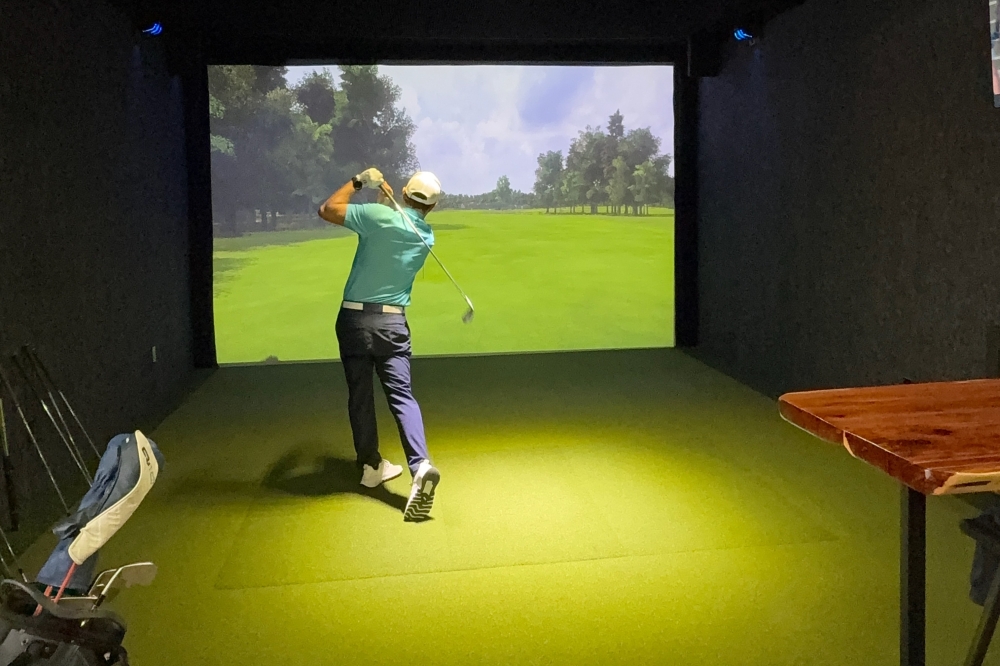 Man golfing indoors