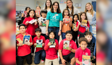 Students at Wayside REAL Learning Academy showcase their new books from Book Drive for Kids, along with Brooke Terry and The University of Texas at Austin student volunteers. (Courtesy Book Drive for Kids)