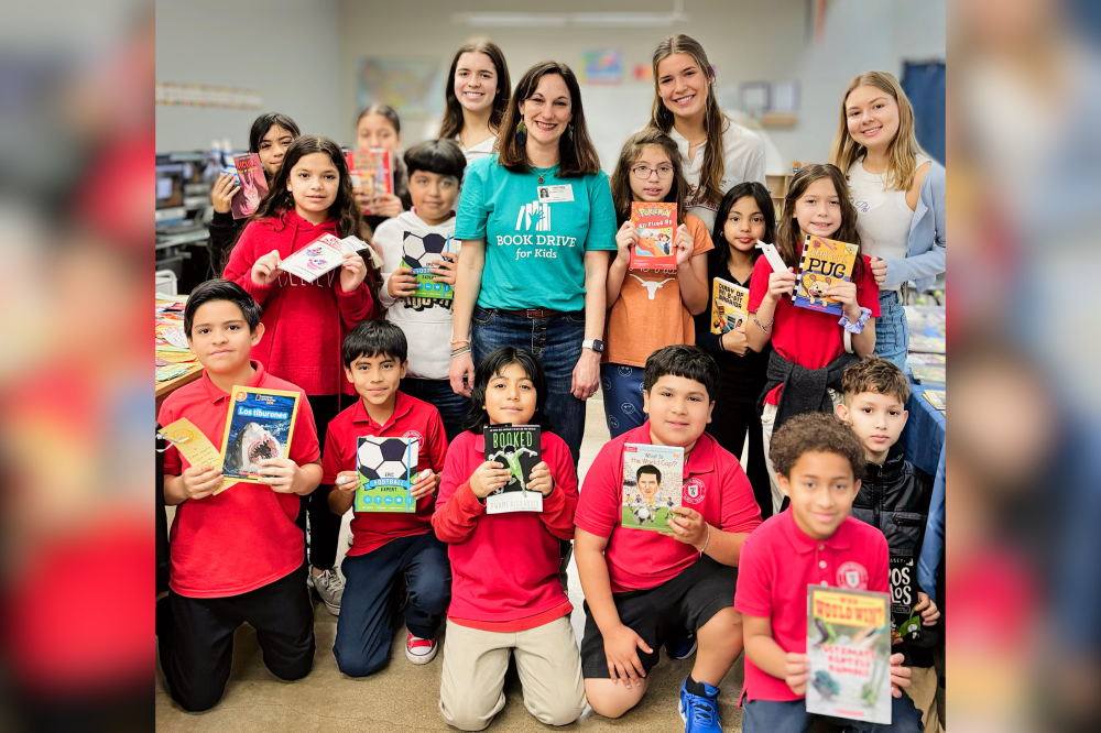 Students at Wayside REAL Learning Academy showcase their new books from Book Drive for Kids, along with Brooke Terry and The University of Texas at Austin student volunteers. (Courtesy Book Drive for Kids)