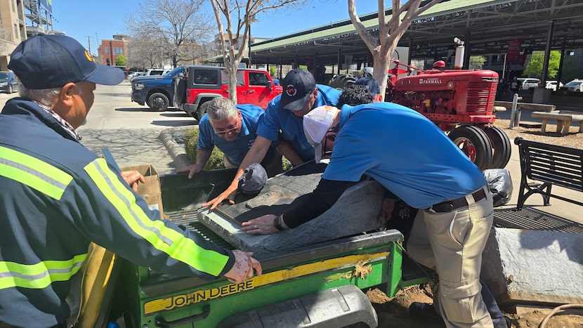 Workers with the Dallas Farmers Market near downtown Dallas load a statue of Cesar Chavez...
