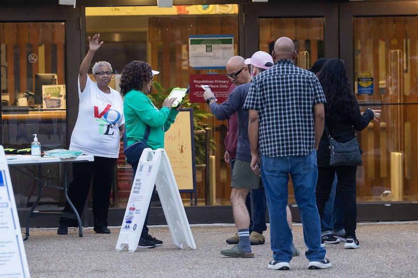 Poll workers collect voters’ information at the Skyline Branch Library as polls open on...
