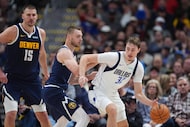 Dallas Mavericks forward Cooper Flagg, right, looks to drive to the rim as Denver Nuggets...