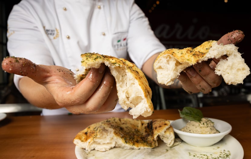 Chef Gimmy Piperku pulls apart the puccia bread served with whipped eggplant at Acquario...