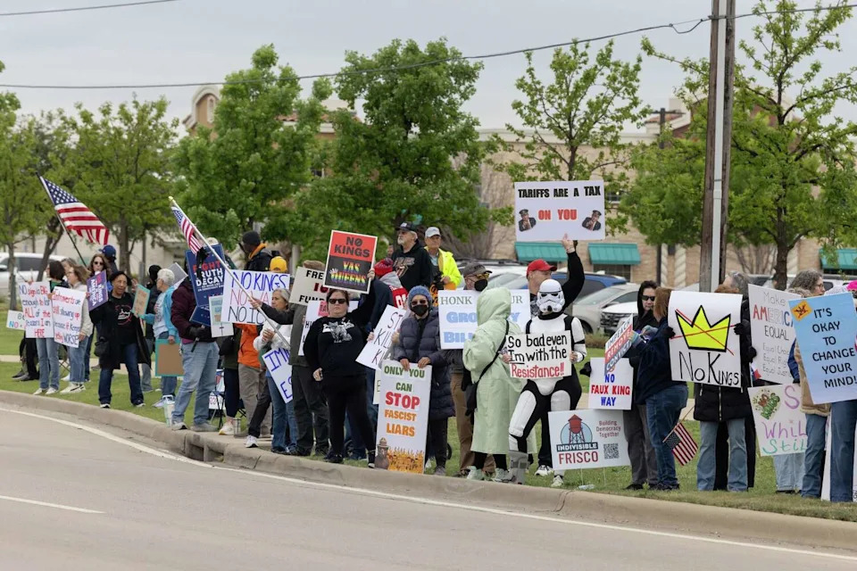 Protesters wave a signs and cheer as traffic passes by during a No Kings protest March 28, 2026 in Frisco. (Azul Sordo/Staff Photographer)