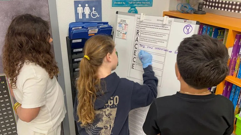 Third grade students Taylor Butters, Claire Stewart and Kane Teran work together during a reading and writing activity at Windsor Park Elementary. (Lauren Wagner)
