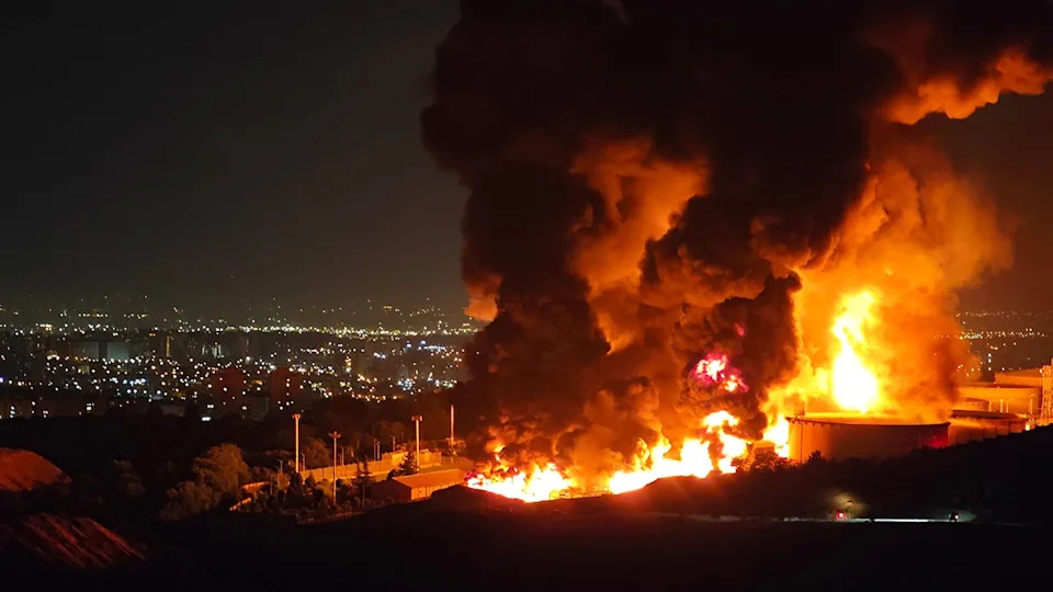 Fire and smoke rise from an Iranian oil depot