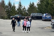 People gather near Temple Israel synagogue in West Bloomfield Township, Mich., as police...