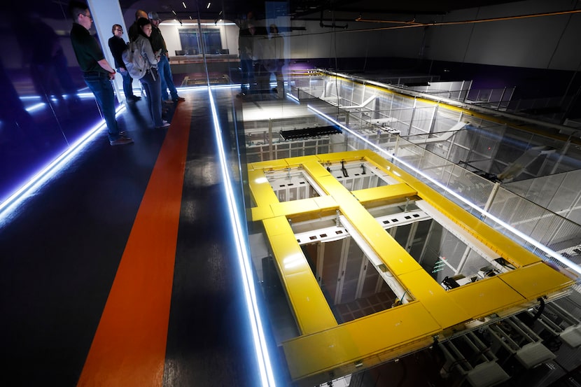 People on a group tour look down into Dallas TX1 data center’s server vault at the NTT Data...