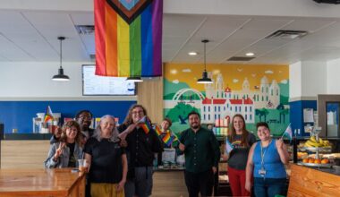 After a gathering at the St. Edward's University Seal, members of the Trans Wellness Organization and PRIDE gathered at Meadows Coffeehouse alongside faculty members Lionel Lopez, Alexandra Barron and Natalie Beck Aguilera. The Pride flag currently at the coffee shop was reinstalled on March 4, 2024 and student leaders from TWO and PRIDE have since organized annual celebrations to remember the protests and what brought the community together.