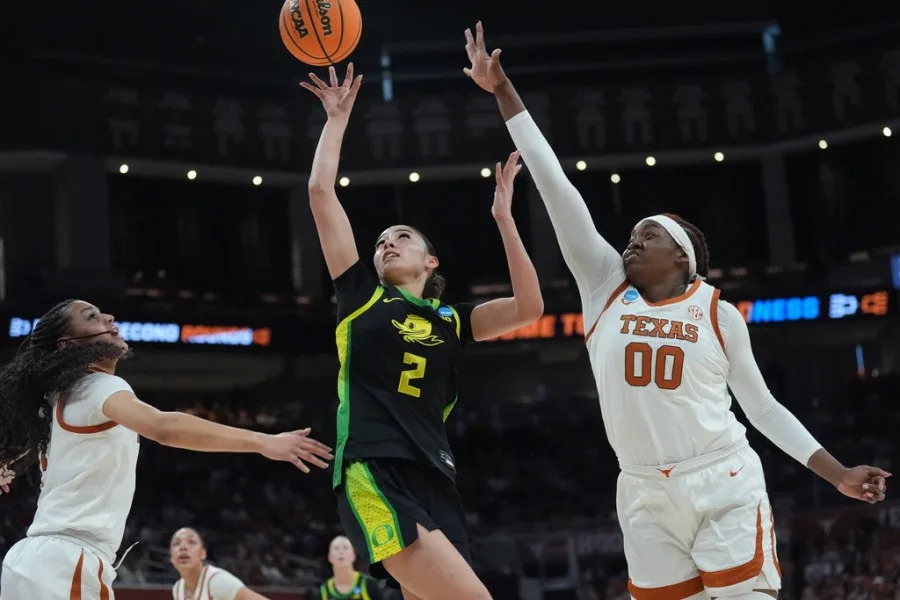 Oregon guard Katie Fiso (2) drives to the basket between Texas guard Jordan Lee (7) and center Kyla Oldacre (00) during the first half in the second round of the NCAA college basketball tournament, Sunday, March 22, 2026, in Austin, Texas. (AP Photo/Eric Gay)