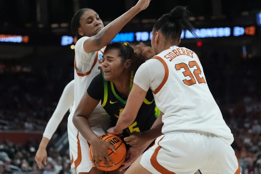 Oregon forward Ehis Etute (35) is pressured by Texas forward Madison Booker, left, and forward Teya Sidberry (32) during the first half in the second round of the NCAA college basketball tournament, Sunday, March 22, 2026, in Austin, Texas. (AP Photo/Eric Gay)