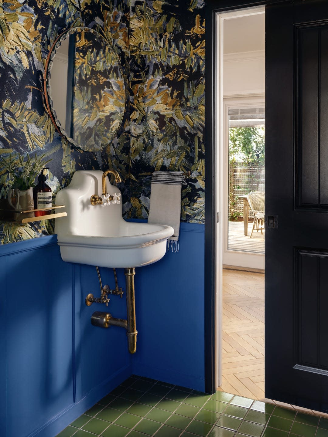 Compact bathroom with bold wallpaper and a stylish sink.