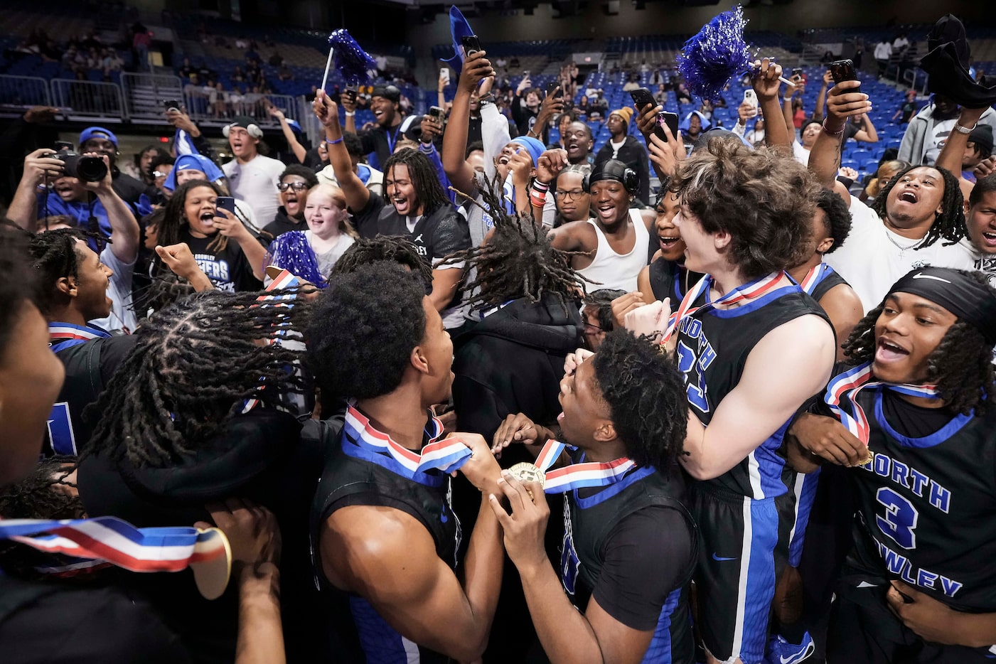 North Crowley players celebrate with their football team after a victory over San Antonio...