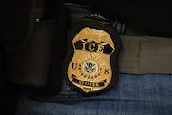 FILE - A federal agent wears an Immigration and Customs Enforcement badge in New York, June...