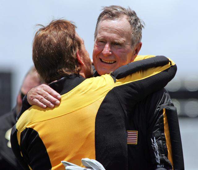 June 13, 2004: Former President George H.W. Bush hugs actor Chuck Norris after his parachute jump in celebration of his 80th birthday in College Station.