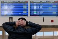 A traveler checks departure times as many flights are cancelled at Beirut Rafik Hariri...