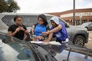 (From left) Zharia Muhammad and Lasanya Williams are helped by campaign greeter Charhonda...
