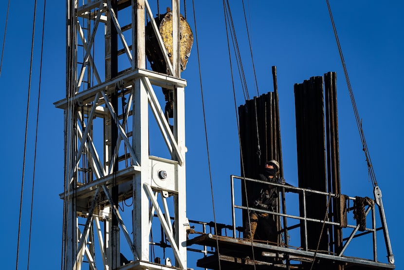 A derrickman guides pipes into a block while drilling a direct lithium extraction test well...